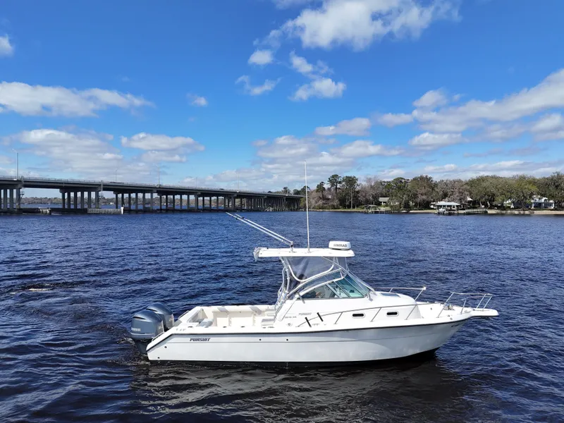 Slide: The Image of 1999 Pursuit 2870 Walkaround boat on a calm river under a blue sky. - 5