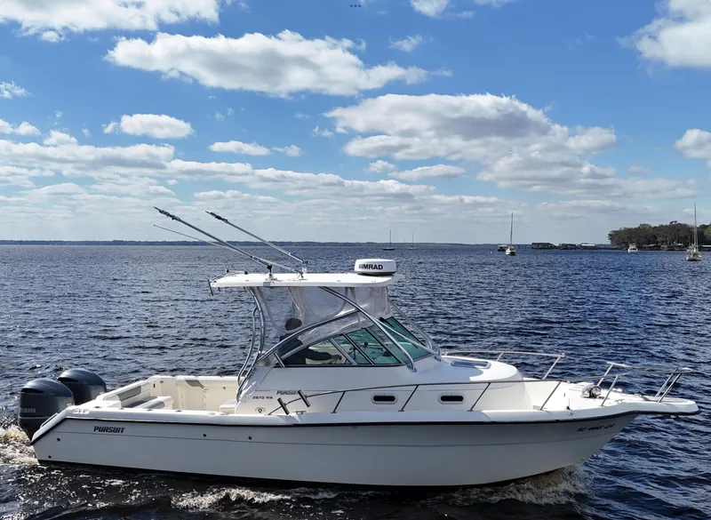Slide: The Image of 1999 Pursuit 2870 Walkaround boat cruising on a sunny day with blue skies. - 9