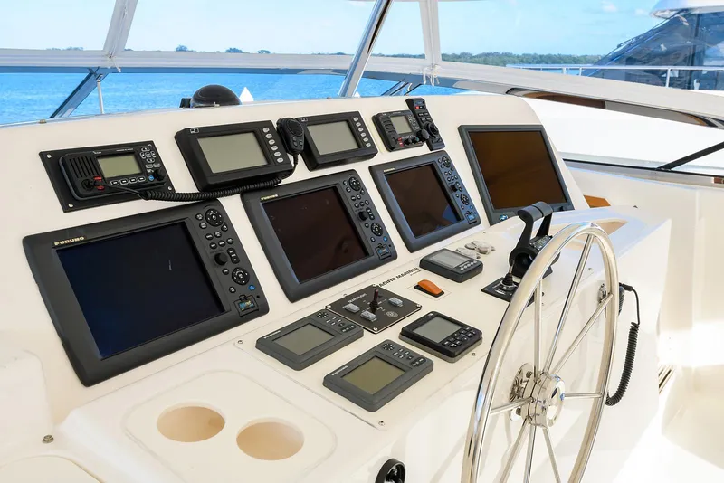 Slide: The Image of Control panel of 2009 Pacific Mariner 85 yacht with multiple navigation screens and steering wheel. - 13