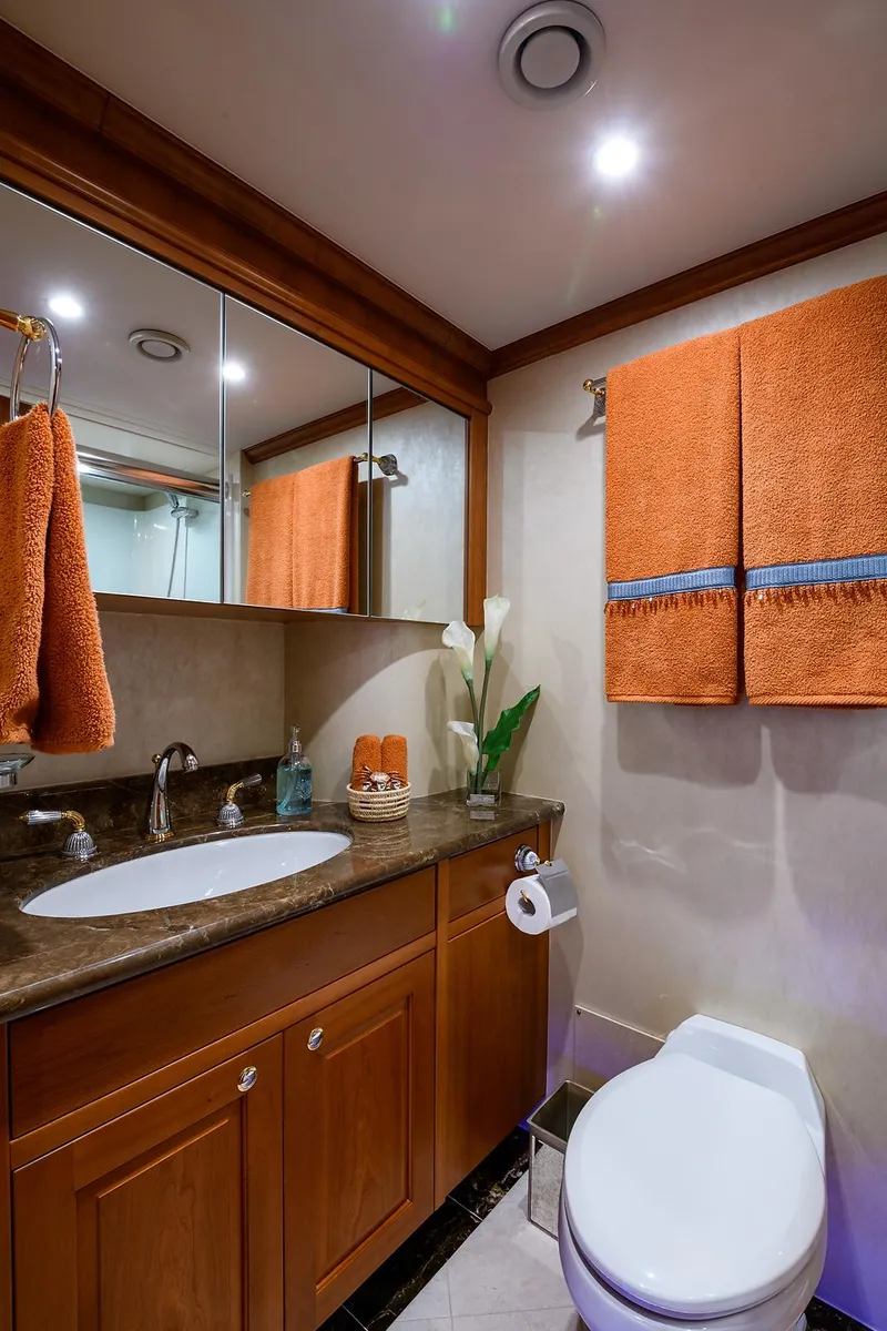 Slide: The Image of Luxurious bathroom in 2009 Pacific Mariner 85 yacht with elegant wood cabinetry and orange towels. - 32