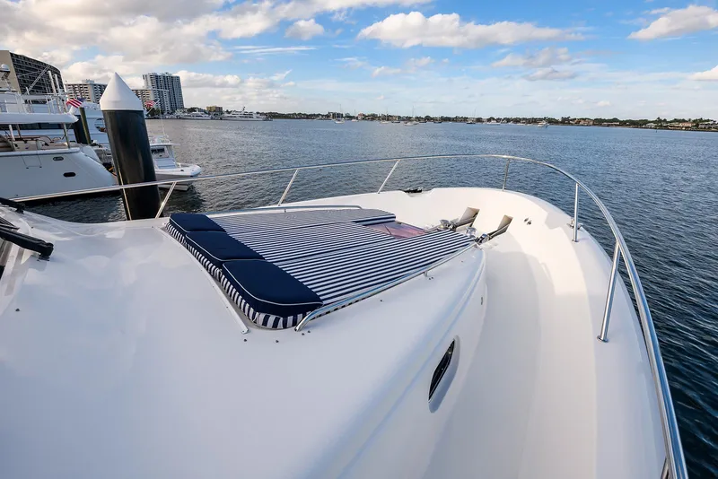 Slide: The Image of 2009 Pacific Mariner 85 yacht with striped sunbed on deck, docked in a marina. - 8