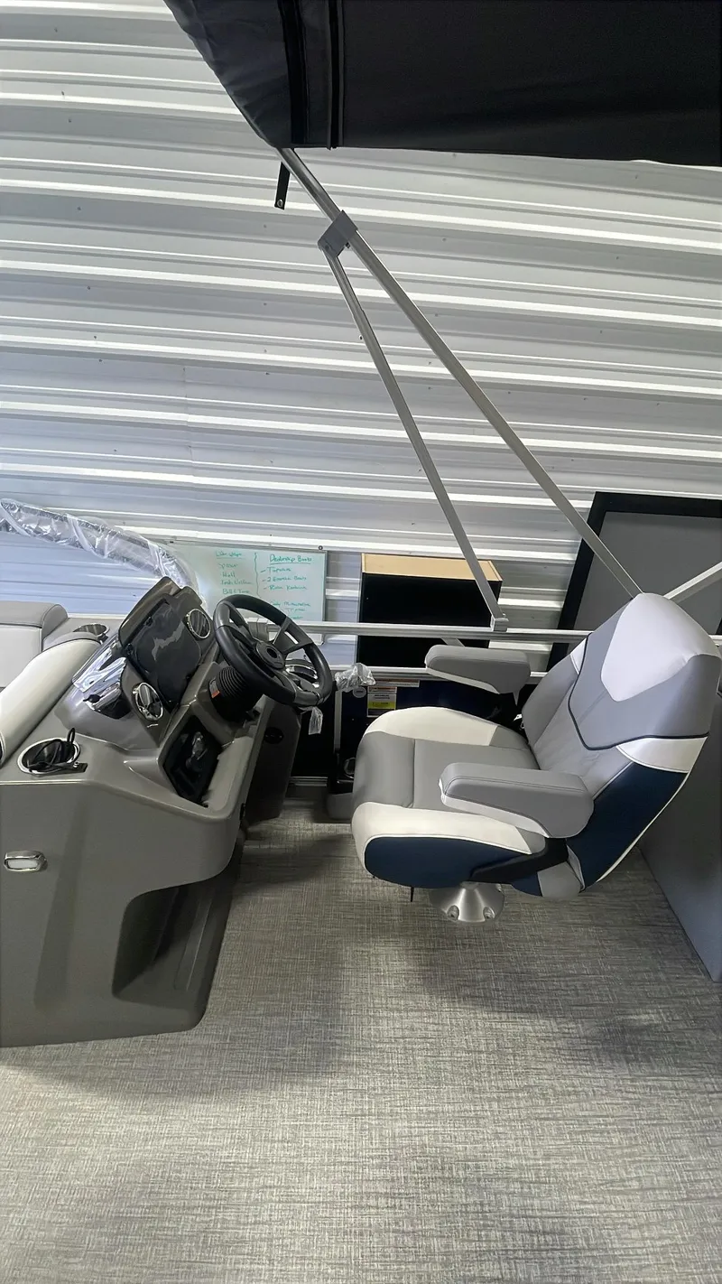 Slide: The Image of 2025 Tahoe Pontoon SP 1980 Quad Lounge interior with steering wheel and captain's chair. - 11