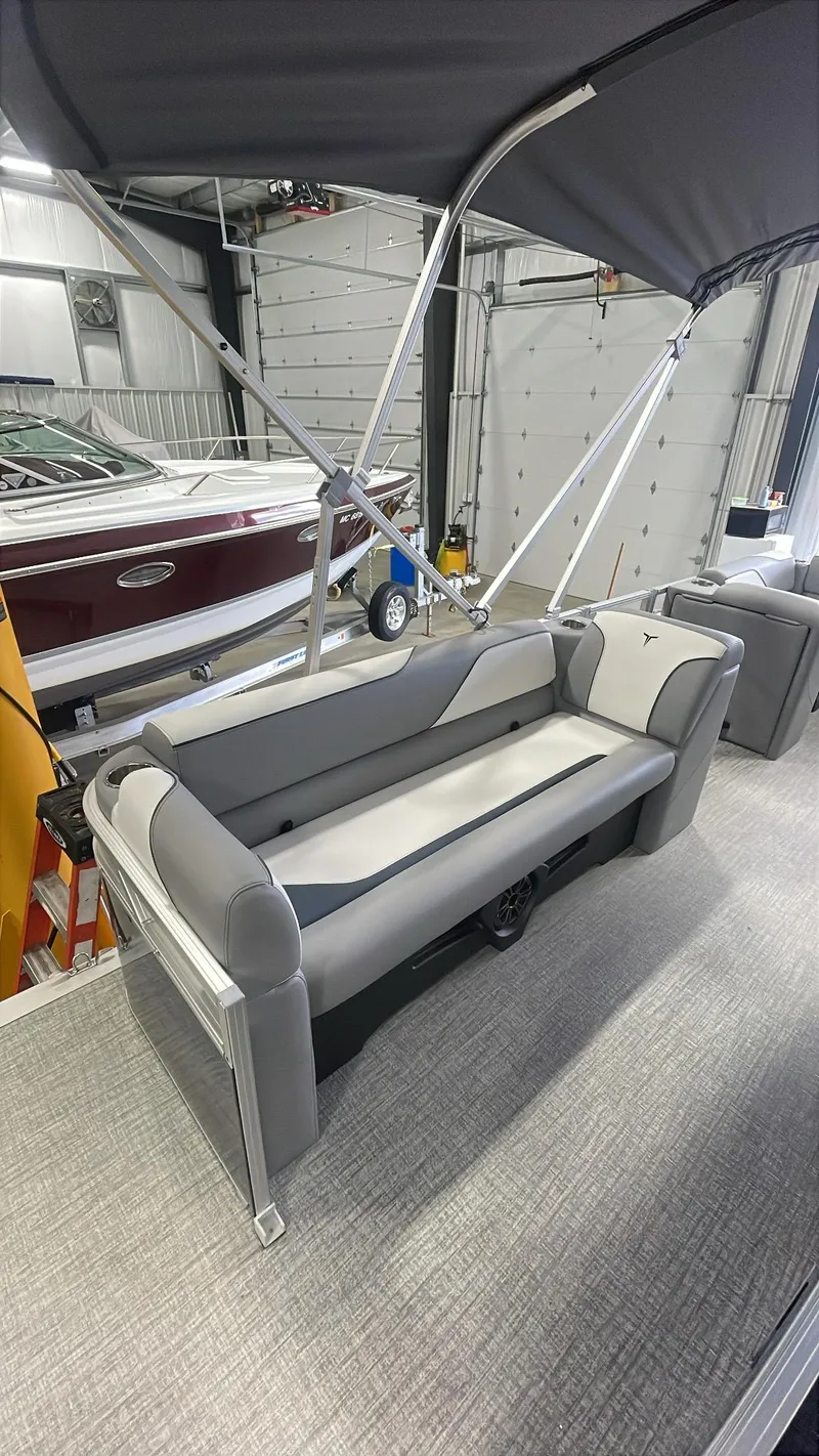 Slide: The Image of 2025 Tahoe Pontoon SP 1980 Quad Lounge with sleek gray seating in a showroom. - 7