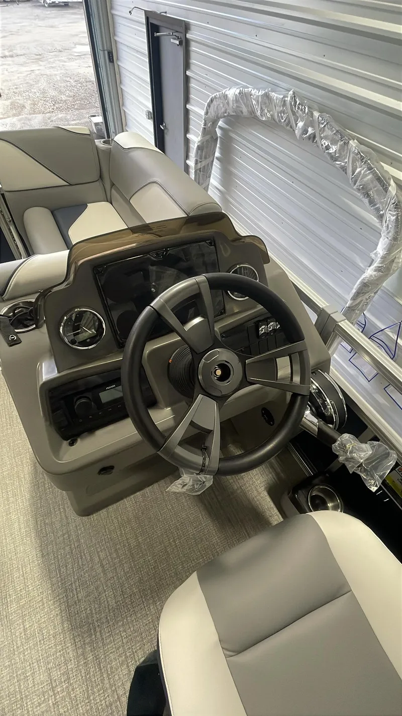 Slide: The Image of 2025 Tahoe Pontoon SP 1980 Quad Lounge steering console with modern controls. - 8