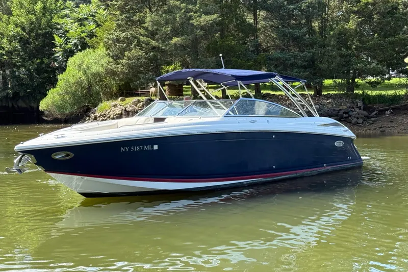 The Image of 2013 Cobalt 302 boat on calm water, surrounded by lush greenery. - 0