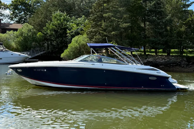 Slide: The Image of 2013 Cobalt 302 boat on a calm river, surrounded by lush greenery. - 1