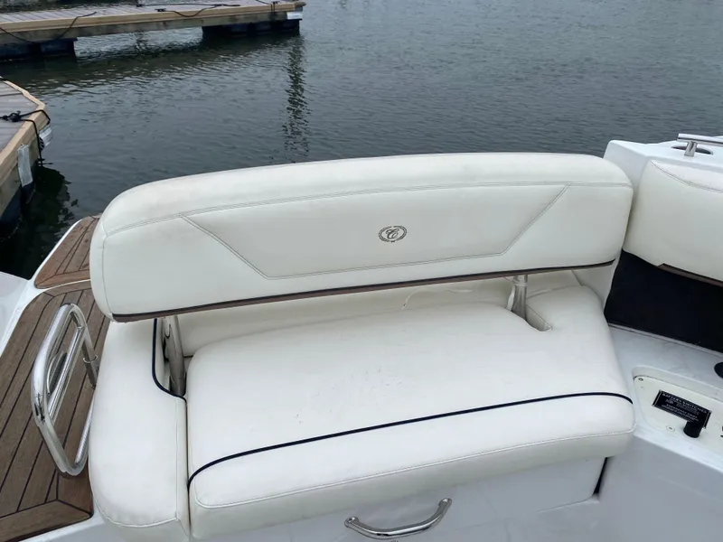 Slide: The Image of White leather seating on a 2013 Cobalt 302 boat, docked by the water. - 10
