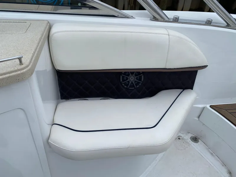 Slide: The Image of White cushioned seating on a 2013 Cobalt 302 boat interior. - 12