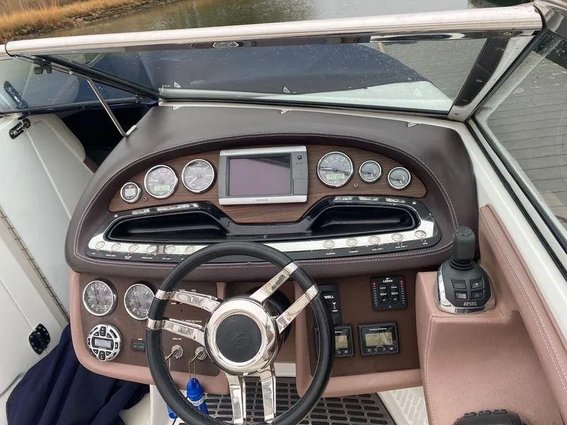 Slide: The Image of 2013 Cobalt 302 boat dashboard with steering wheel and control panel. - 15