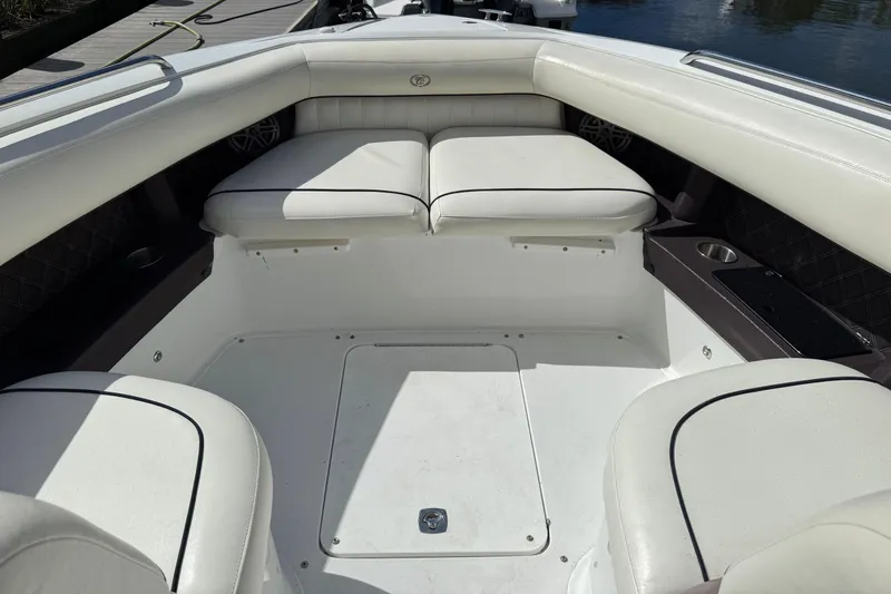 Slide: The Image of 2013 Cobalt 302 boat interior with white cushioned seating and cup holders. - 18