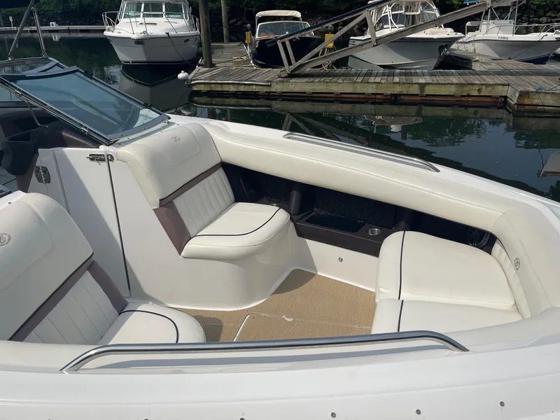 Slide: The Image of 2013 Cobalt 302 boat interior with white seating, docked at a marina. - 20