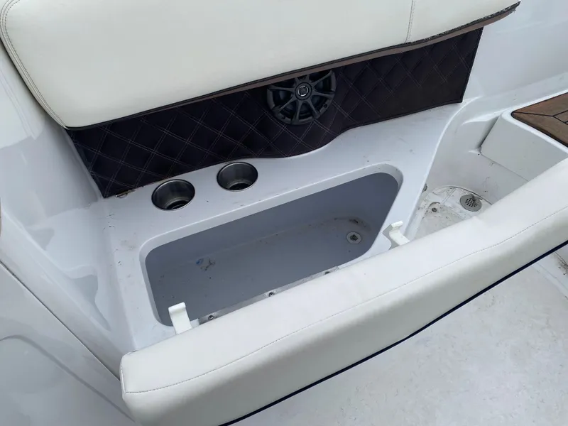 Slide: The Image of Interior of a 2013 Cobalt 302 boat featuring storage compartment and cup holders. - 25