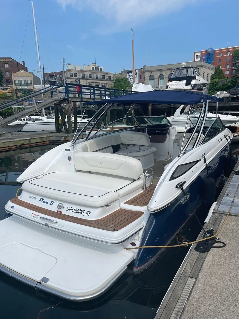 Slide: The Image of 2013 Cobalt 302 boat docked at a marina, featuring a sleek design and spacious seating. - 28