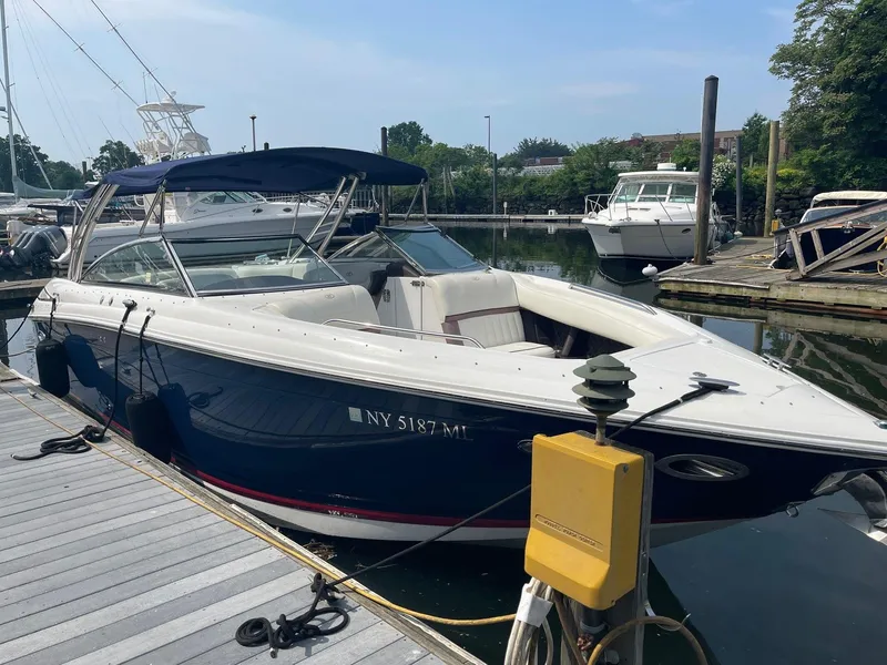 Slide: The Image of 2013 Cobalt 302 boat docked at marina, featuring sleek design and blue hull. - 29