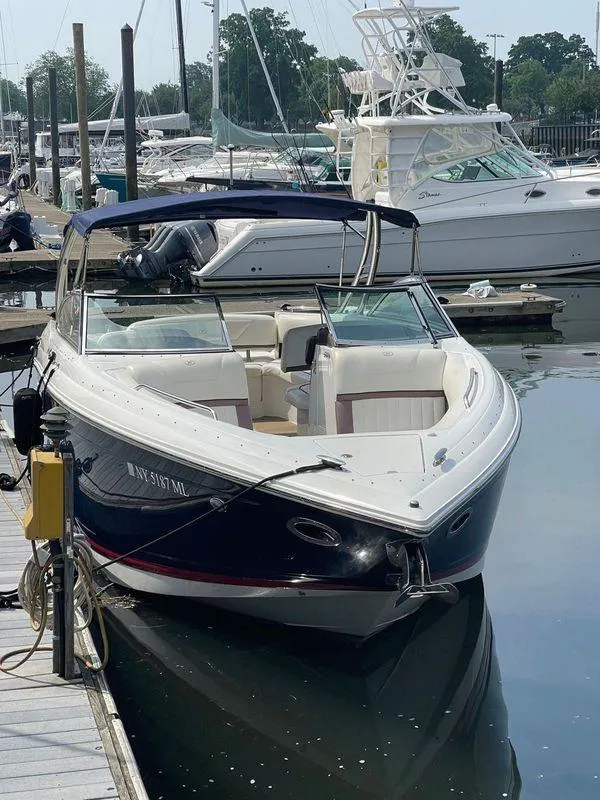 Slide: The Image of 2013 Cobalt 302 boat docked at marina, featuring sleek design and spacious seating. - 30