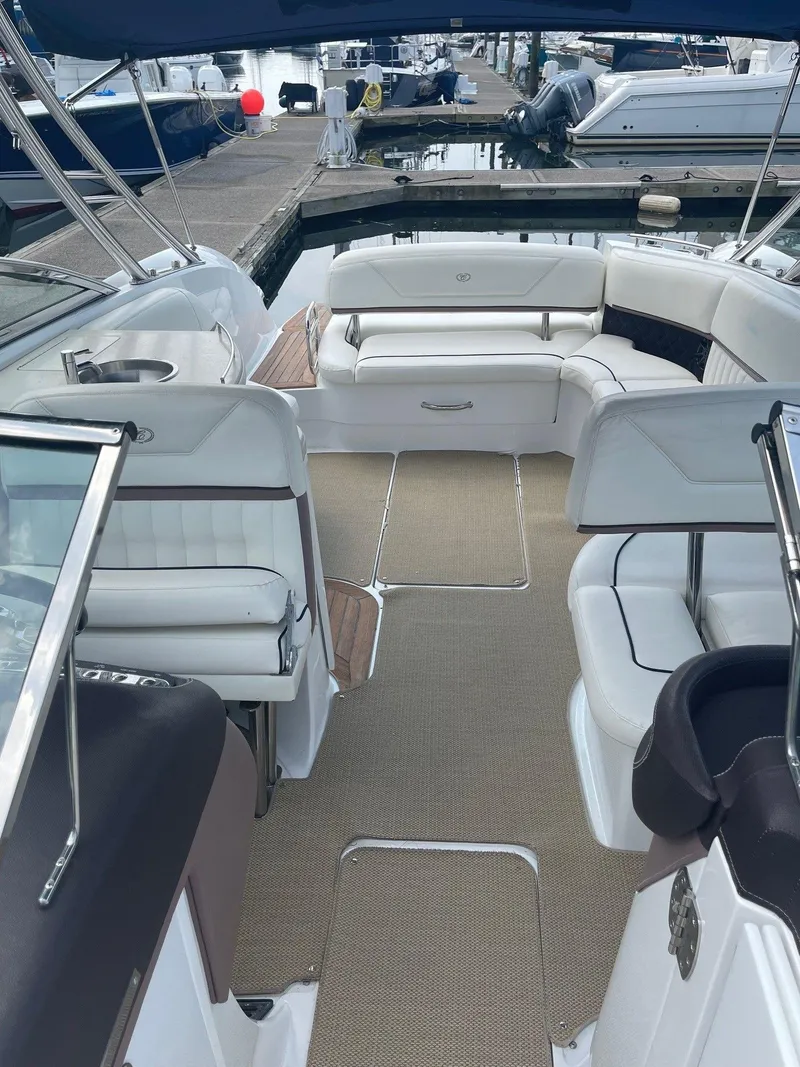 Slide: The Image of 2013 Cobalt 302 boat interior with white seating, docked at marina. - 7