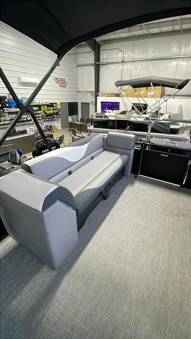 Slide: The Image of 2025 Tahoe Pontoon SP 2385 QL interior with sleek seating in showroom. - 10
