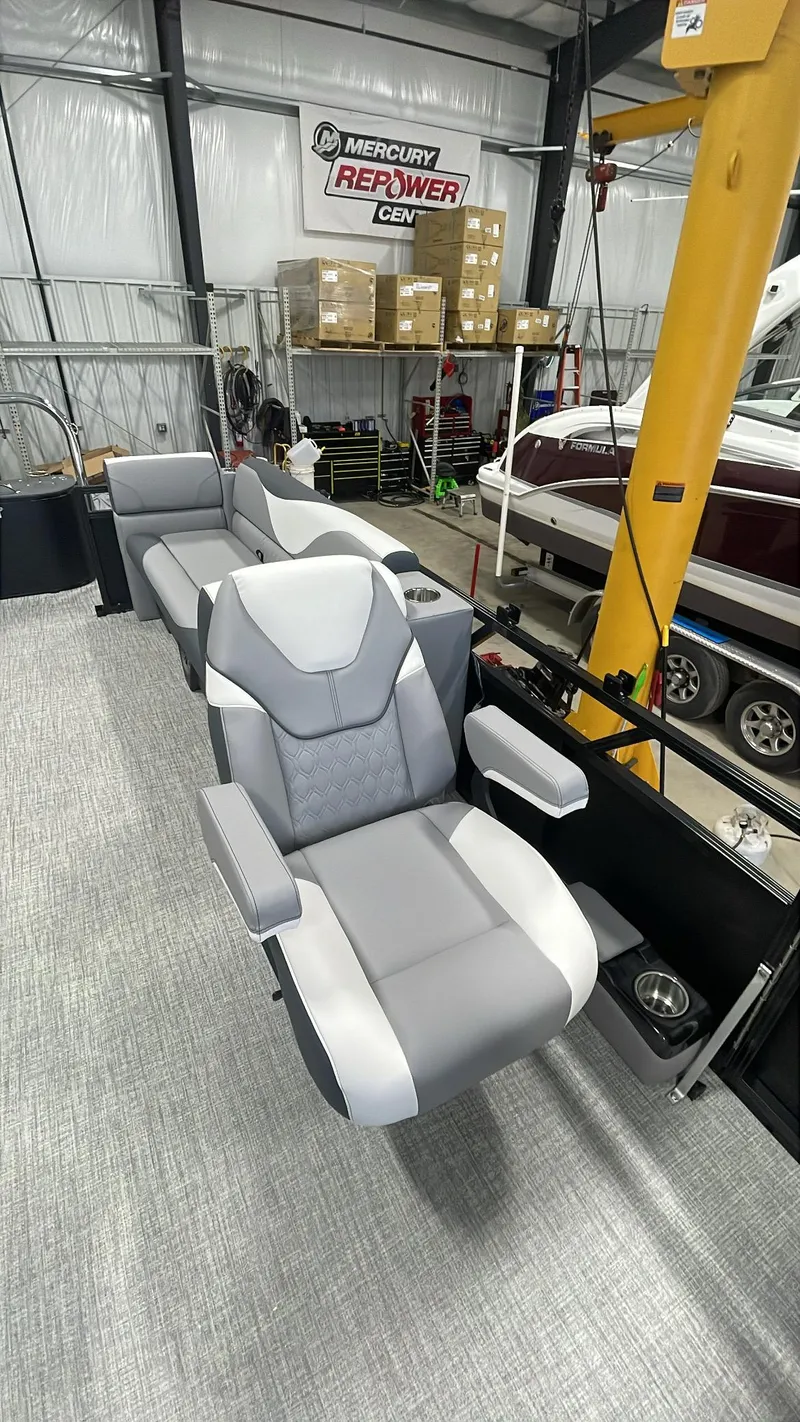 Slide: The Image of 2025 Tahoe Pontoon SP 2385 QL interior with modern seating in a workshop. - 14
