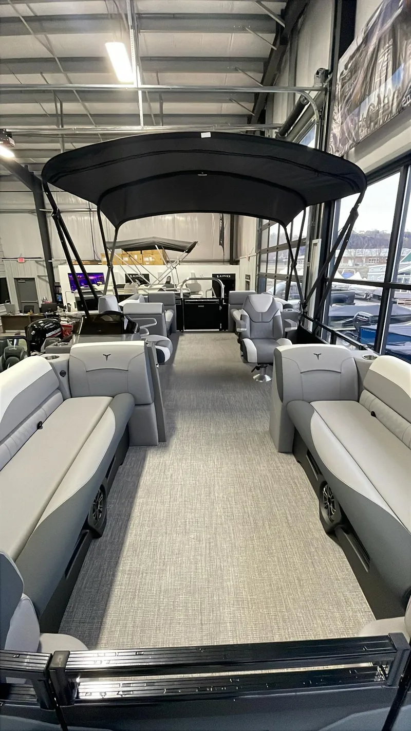 Slide: The Image of 2025 Tahoe Pontoon SP 2385 QL with spacious seating and canopy in a showroom. - 7