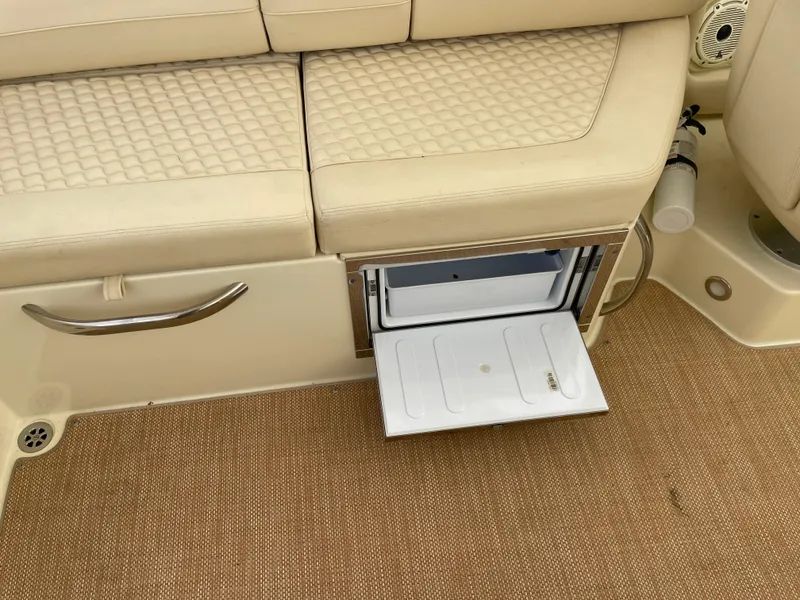 Slide: The Image of 2020 Chris-Craft Launch 28GT interior with beige seating and built-in storage compartment. - 10