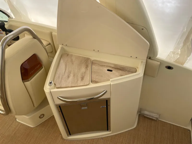 Slide: The Image of 2020 Chris-Craft Launch 28GT interior with beige seating and storage compartment. - 14
