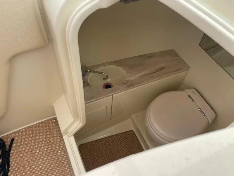 Slide: The Image of 2020 Chris-Craft Launch 28GT boat interior with compact bathroom, featuring a sink and toilet. - 21