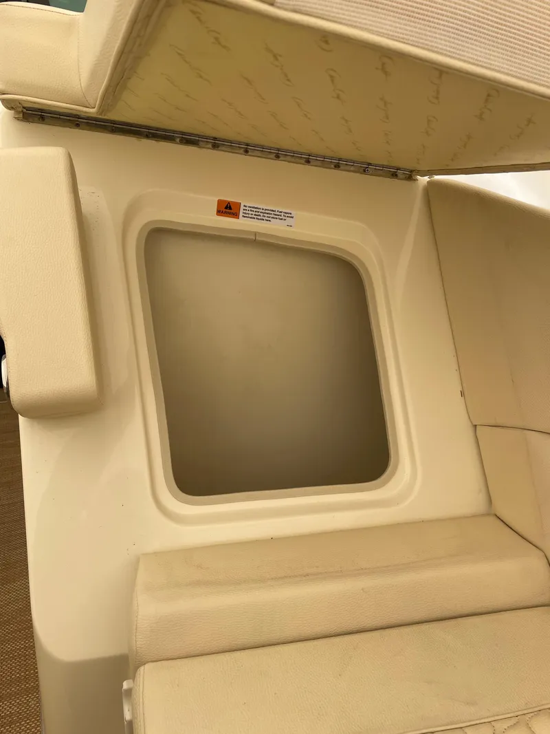 Slide: The Image of 2020 Chris-Craft Launch 28GT interior detail, featuring a storage compartment with beige upholstery. - 31