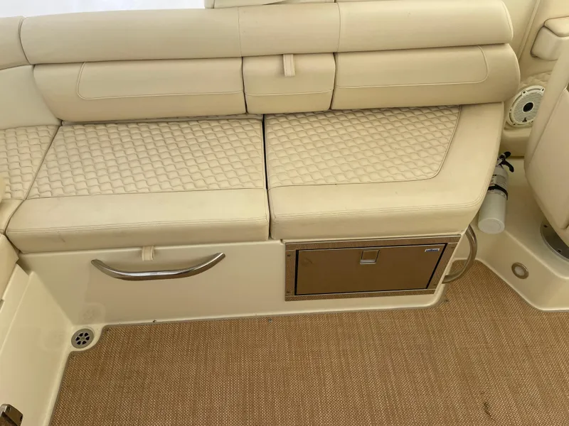 Slide: The Image of 2020 Chris-Craft Launch 28GT interior seating with beige upholstery and storage compartment. - 9