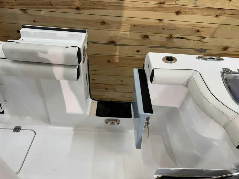 Slide: The Image of 2025 Tidewater 256 CC Adventure boat interior with white seating and wooden paneling. - 10