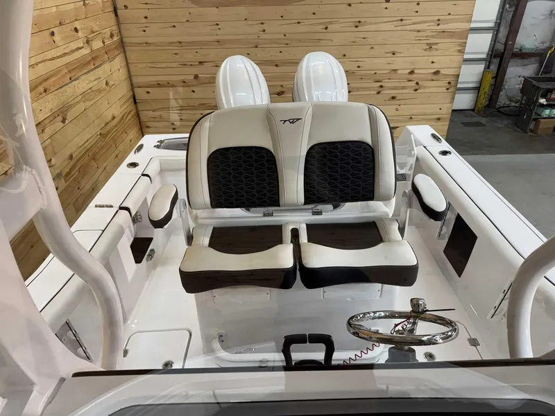 Slide: The Image of 2025 Tidewater 256 CC Adventure boat interior with dual seats and steering wheel. - 11