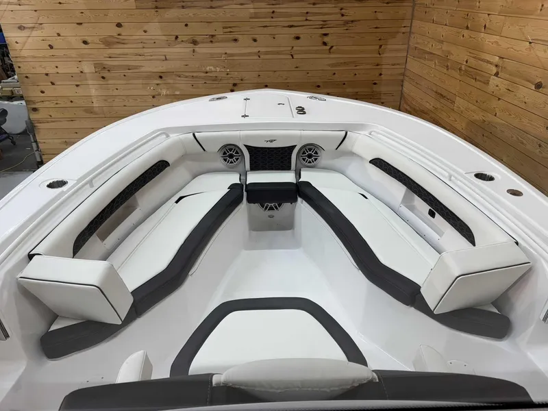 Slide: The Image of 2025 Tidewater 256 CC Adventure boat interior with sleek white seating and wood-paneled walls. - 12
