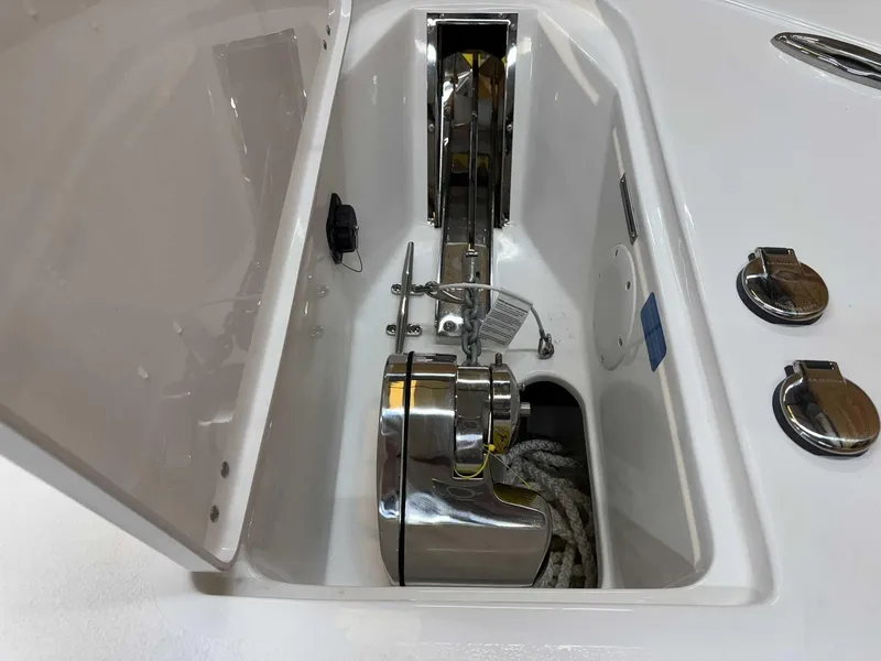 Slide: The Image of 2025 Tidewater 256 CC Adventure boat anchor compartment with stainless steel fittings and rope storage. - 14