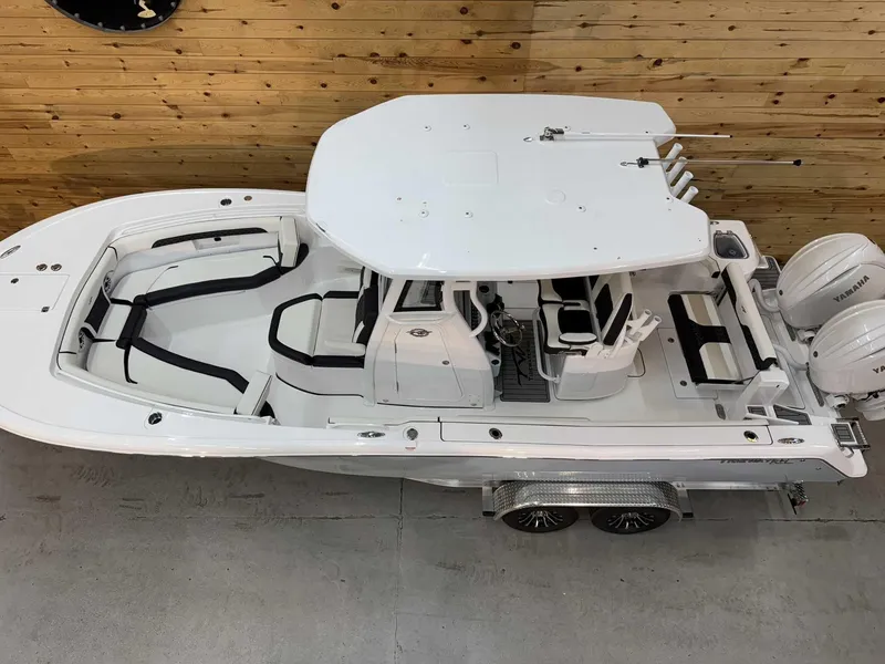 Slide: The Image of 2025 Tidewater 256 CC Adventure boat in showroom, featuring sleek design and dual engines. - 16