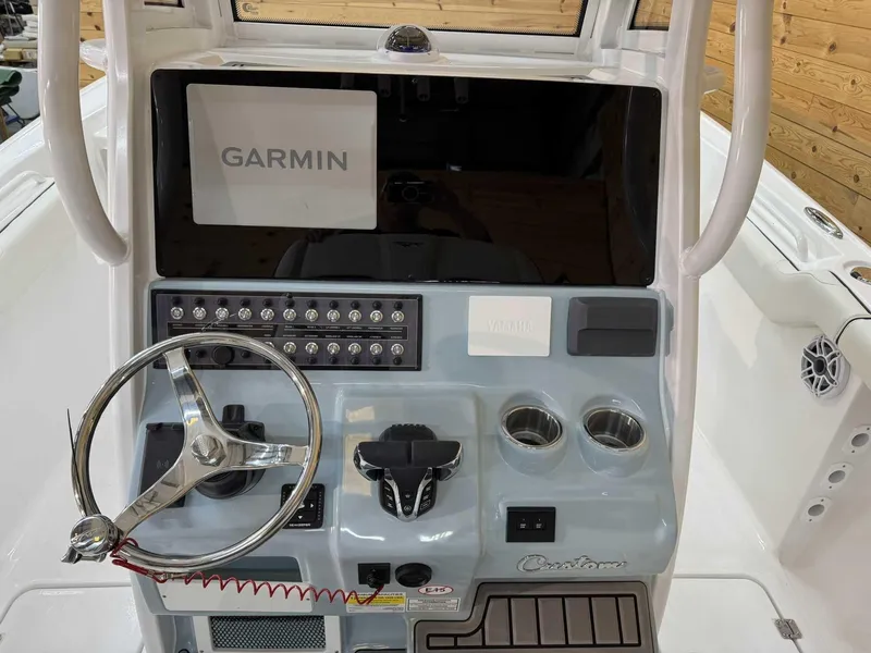 Slide: The Image of 2025 Tidewater 256 CC Adventure boat console with Garmin display and steering wheel. - 6