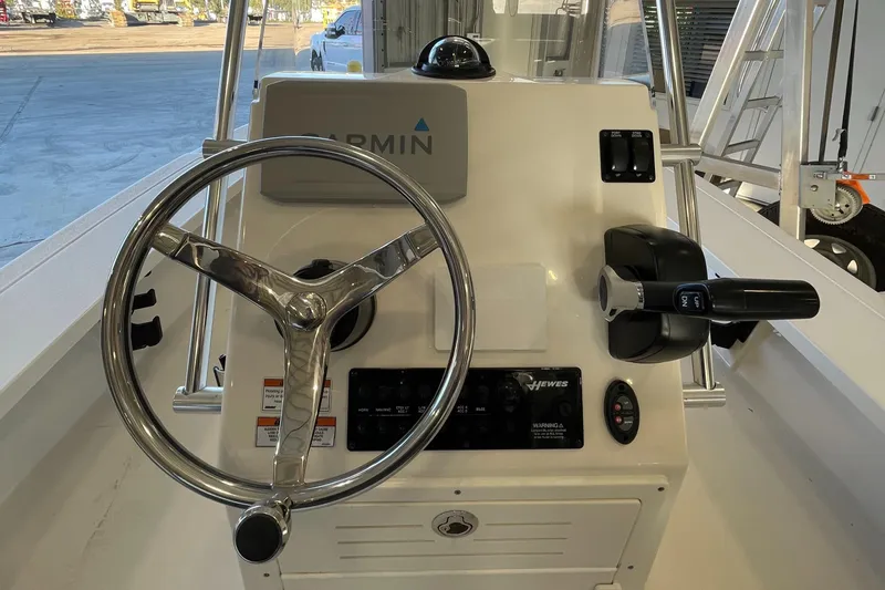 Slide: The Image of 2021 Hewes Redfisher 16 boat console with steering wheel and Garmin navigation system. - 3