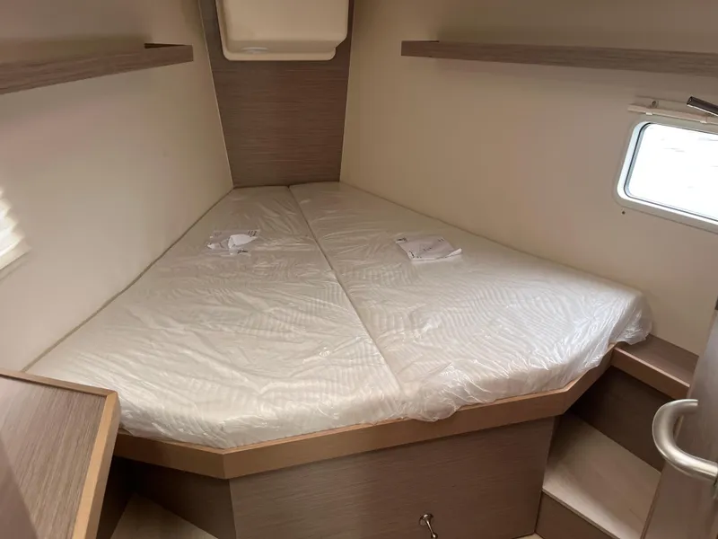 Slide: The Image of 2021 Hanse 418 yacht cabin with a cozy triangular bed and window. - 46