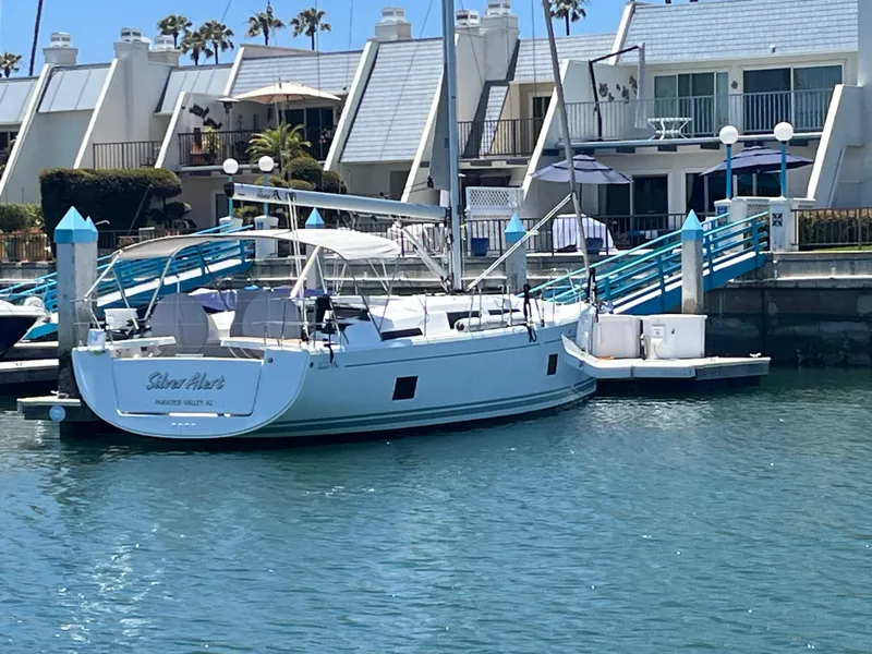 Slide: The Image of 2021 Hanse 418 yacht docked near waterfront homes, clear blue sky. - 10