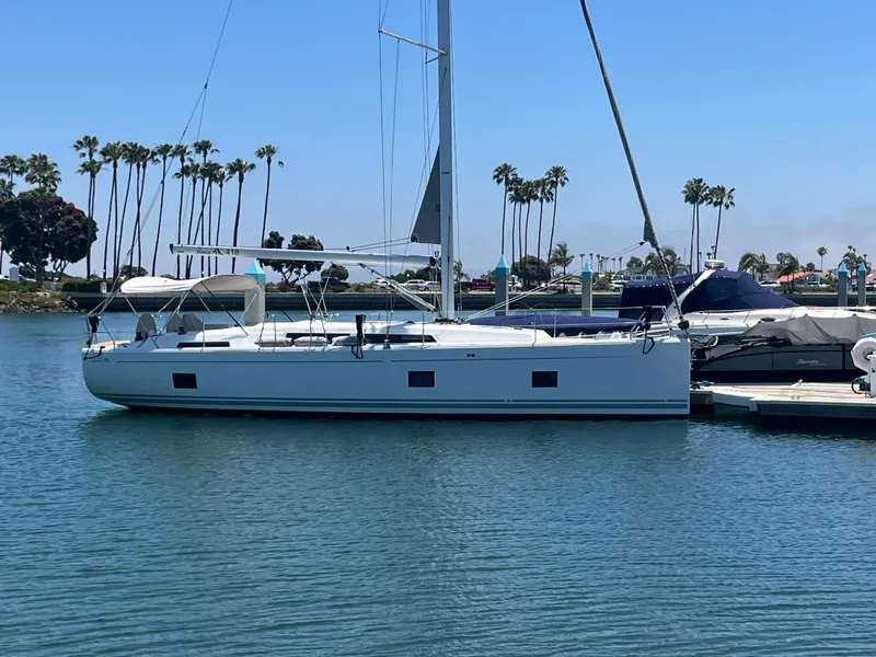 Slide: The Image of 2021 Hanse 418 sailboat docked in a marina with palm trees in the background. - 11