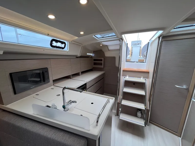 Slide: The Image of Modern interior of 2021 Hanse 418 yacht, featuring sleek kitchen and wooden stairs. - 15