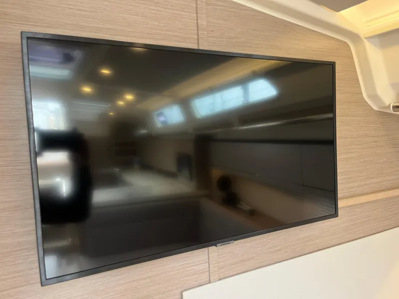 Slide: The Image of Flat-screen TV inside 2021 Hanse 418 yacht, reflecting interior cabin details. - 45