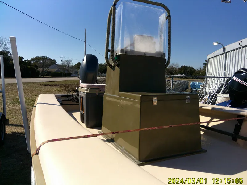 Slide: The Image of 2017 Jones Brothers 17 BATEAU boat with console and outboard motor, parked outdoors. - 14