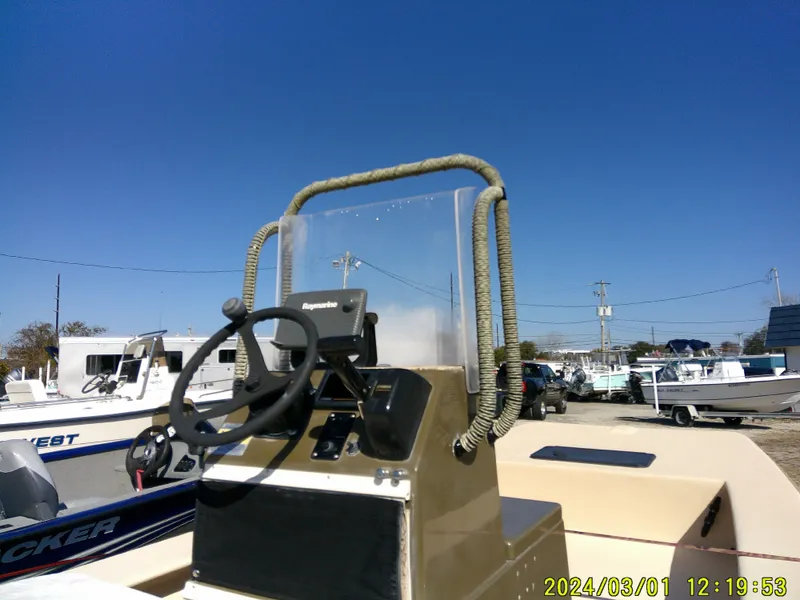 Slide: The Image of 2017 Jones Brothers 17 BATEAU boat console with steering wheel, outdoors under clear blue sky. - 18