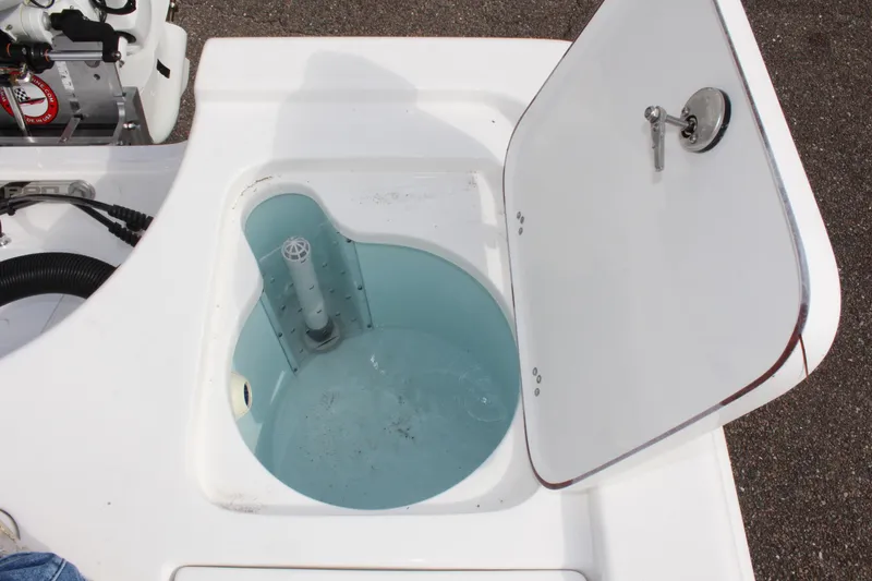 Slide: The Image of Livewell compartment on a 2025 Sea Pro 230 Bay boat, open lid showing interior. - 10