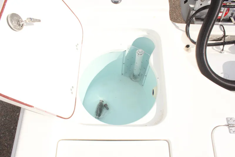 Slide: The Image of Livewell compartment on a 2025 Sea Pro 230 Bay boat, open lid, white interior. - 14