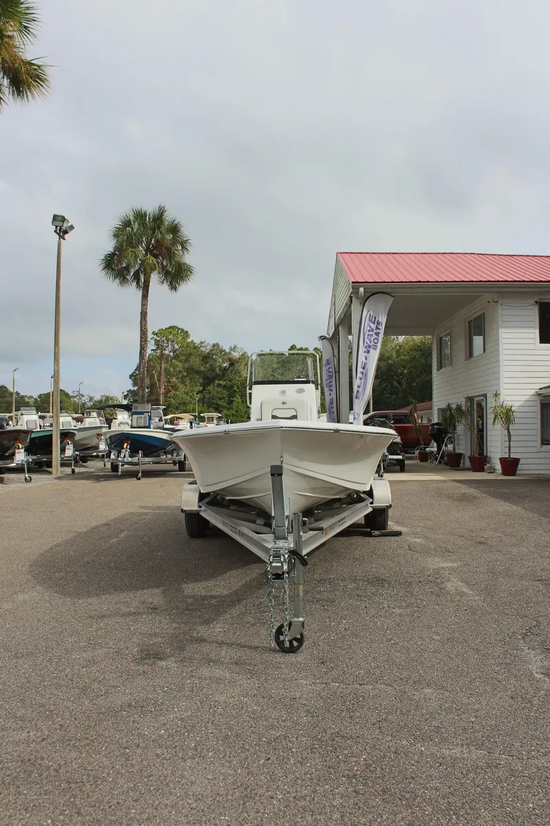 Slide: The Image of 2025 Sea Pro 230 Bay boat on trailer at dealership, palm trees in background. - 37