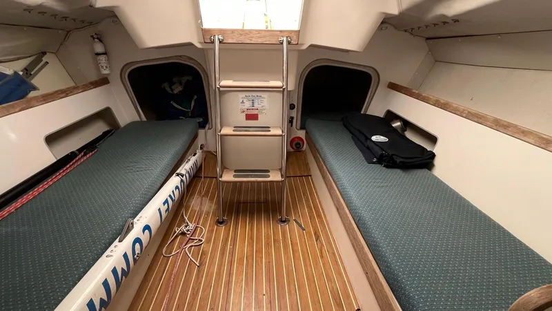 Slide: The Image of Interior of 2001 J Boats J/105 sailboat, featuring twin berths and wooden flooring. - 16