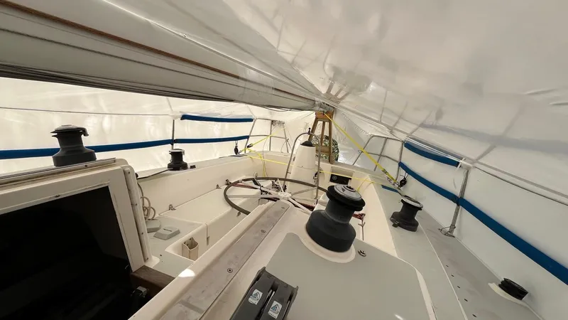 Slide: The Image of 2001 J Boats J/105 sailboat cockpit under cover, showcasing steering and winches. - 8