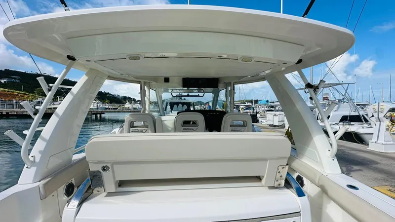 Slide: The Image of 2017 Boston Whaler 420 Outrage boat docked at marina, showcasing spacious seating and sleek design. - 14