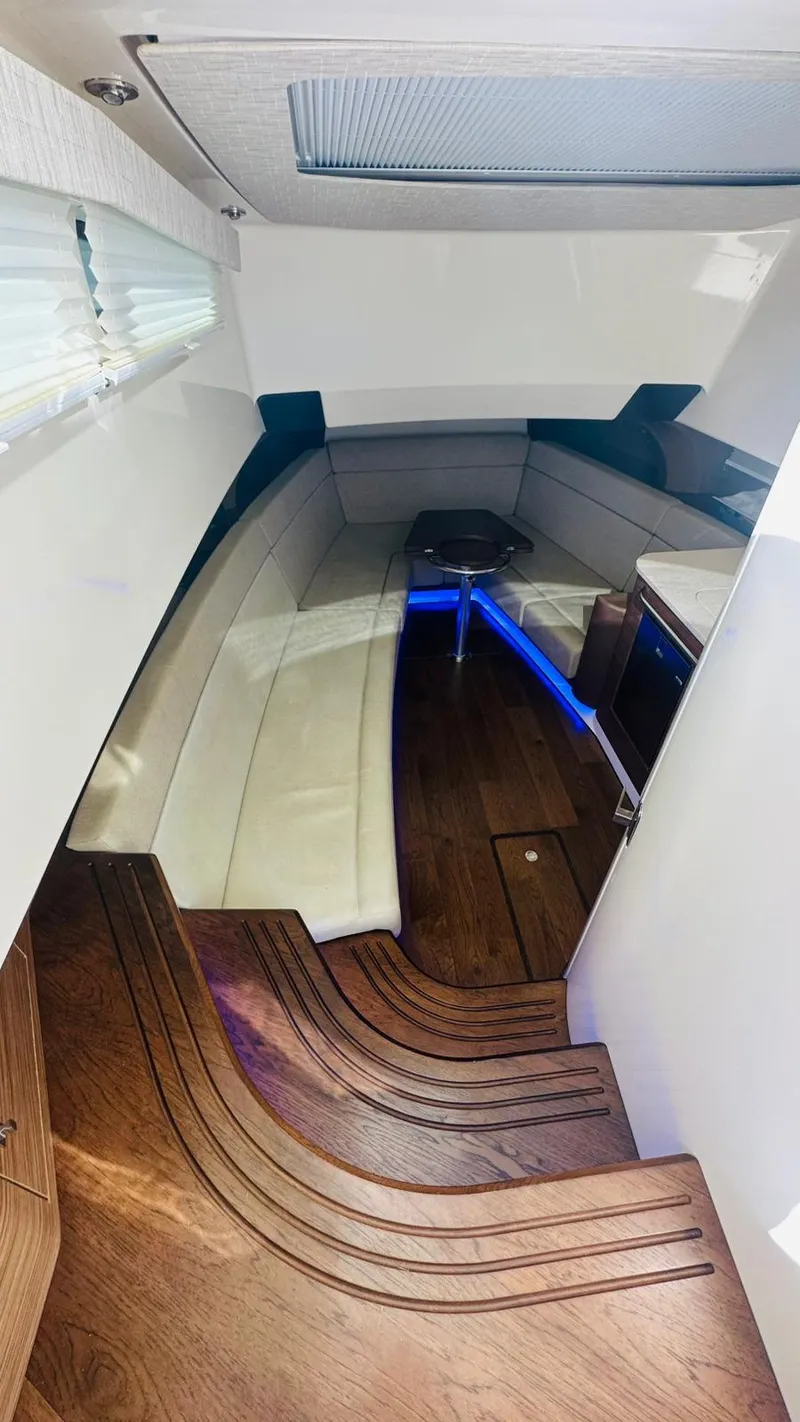 Slide: The Image of 2017 Boston Whaler 420 Outrage cabin interior with wood flooring and white seating. - 16