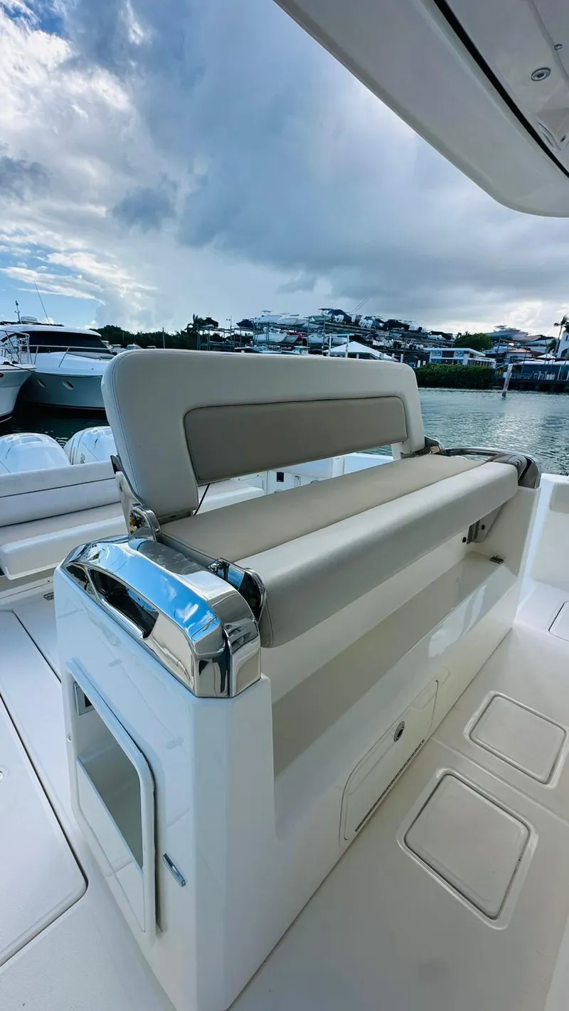 Slide: The Image of 2017 Boston Whaler 420 Outrage boat interior with seating, docked by the water. - 17